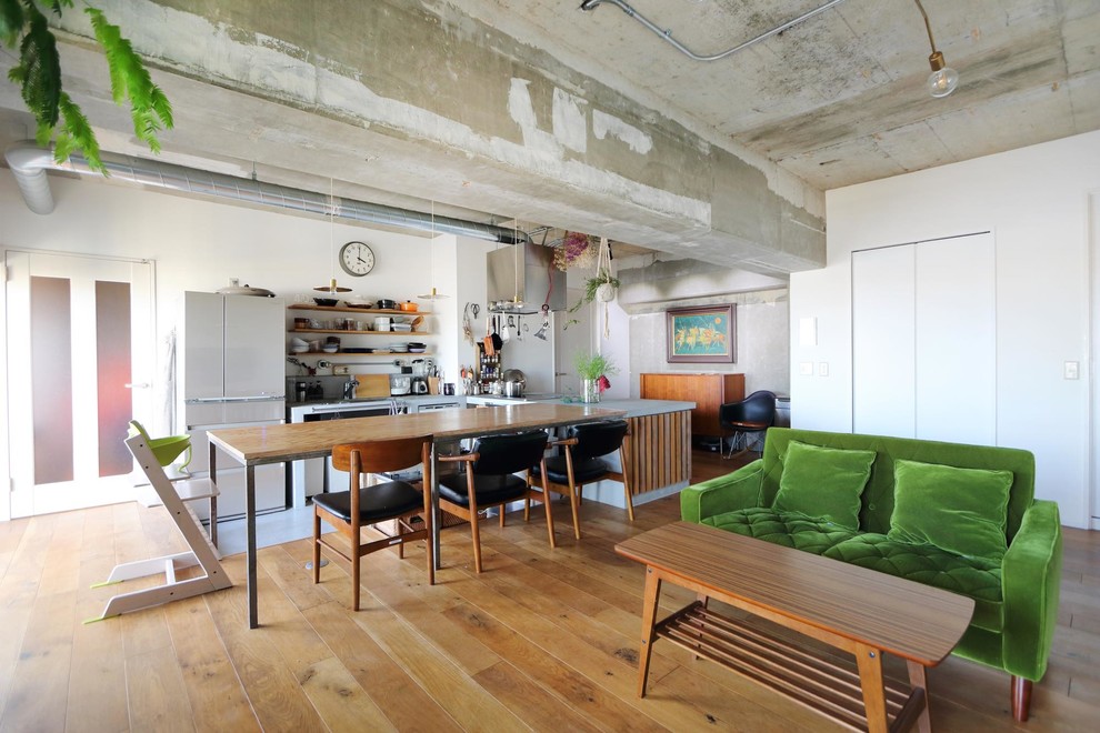 Inspiration pour une salle à manger ouverte sur le salon chalet avec un mur blanc, un sol en bois brun et un sol marron.