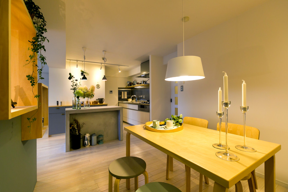 Aménagement d'une salle à manger ouverte sur le salon scandinave avec un mur multicolore, parquet peint et un sol beige.