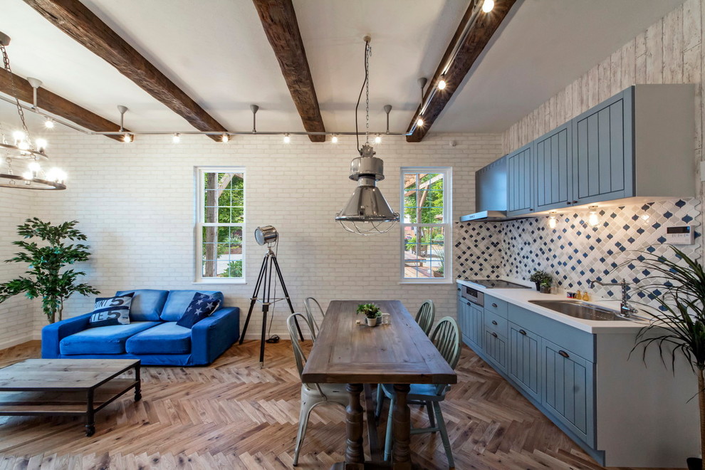 Esempio di una sala da pranzo aperta verso il soggiorno stile marinaro con pareti bianche e parquet chiaro