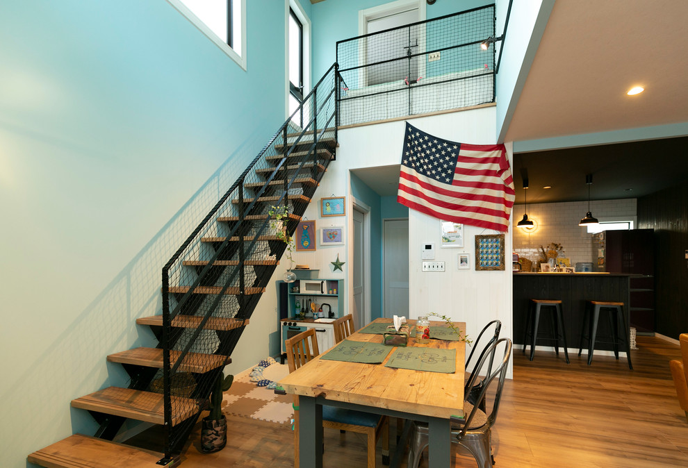 Ispirazione per una sala da pranzo aperta verso il soggiorno minimalista di medie dimensioni con pareti blu, pavimento in legno massello medio e pavimento marrone
