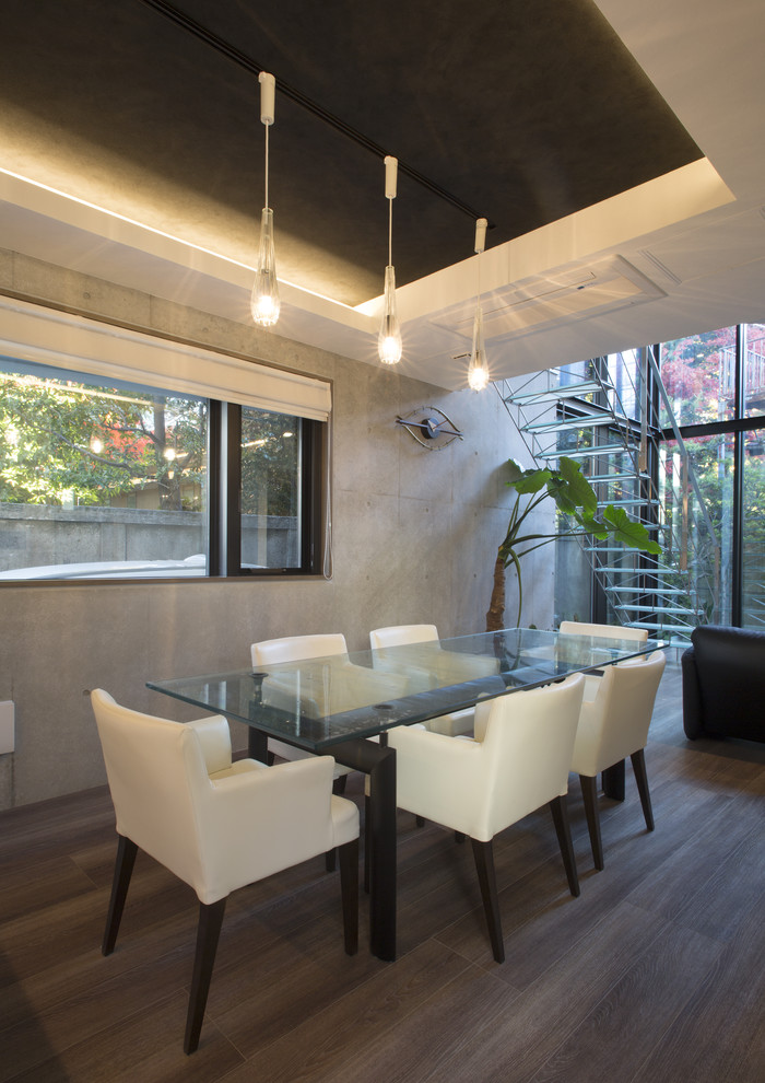 На фото: столовая в стиле модернизм с серыми стенами, деревянным полом и коричневым полом