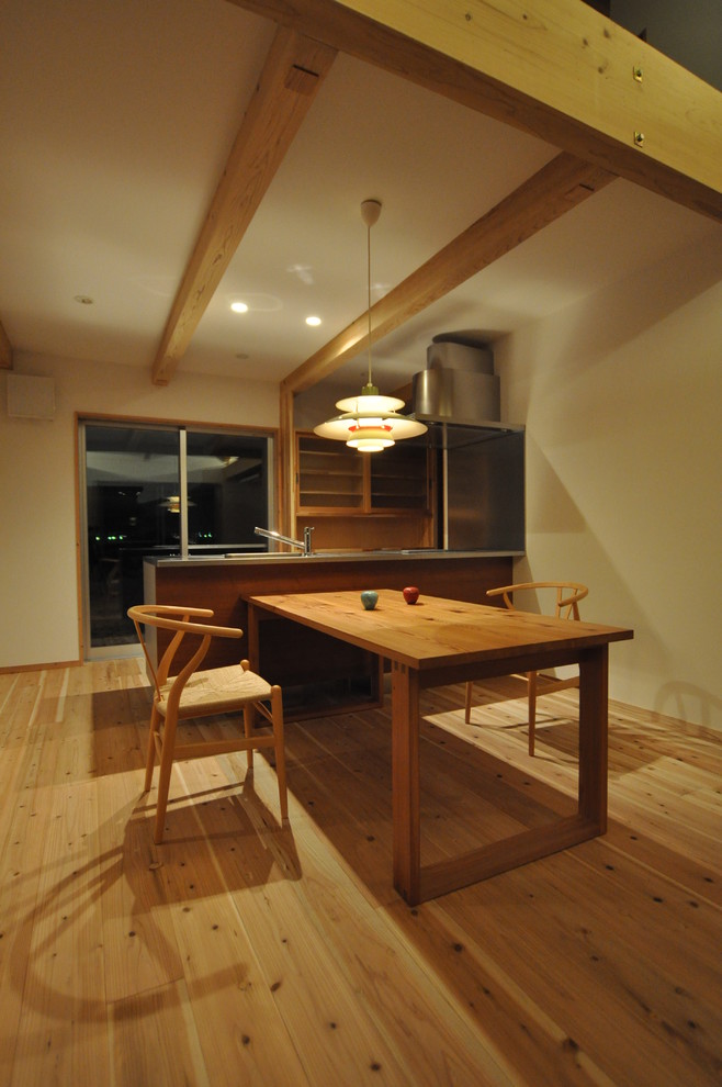 Idee per una sala da pranzo aperta verso la cucina country con pareti beige e pavimento in legno massello medio