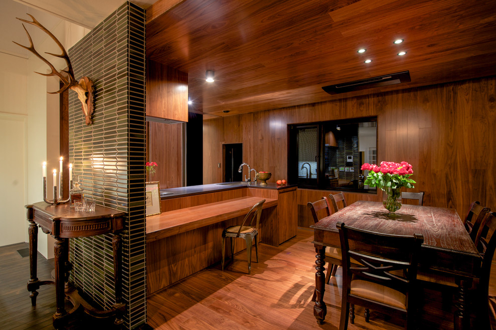 他の地域にあるミッドセンチュリースタイルのおしゃれなダイニングキッチン (茶色い壁、無垢フローリング、茶色い床) の写真