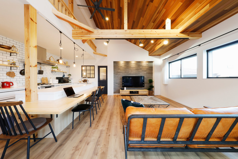 Aménagement d'une salle à manger ouverte sur le salon industrielle avec un mur blanc, un sol en bois brun et un sol marron.