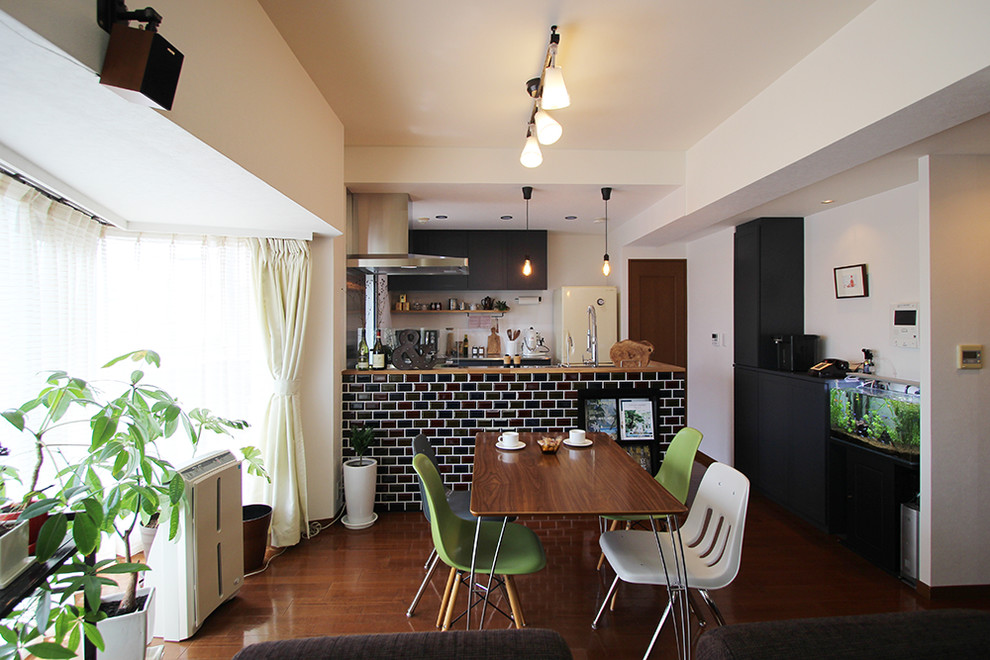 Foto di una piccola sala da pranzo bohémian con pareti bianche, pavimento in compensato, nessun camino e pavimento marrone