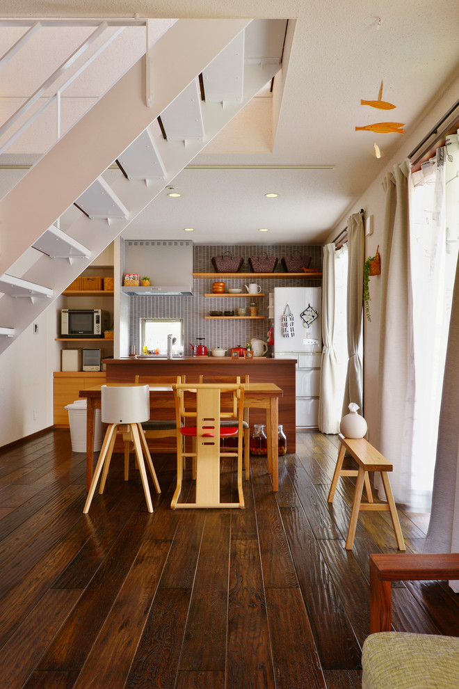 Foto di una sala da pranzo aperta verso il soggiorno minimal con pareti bianche e pavimento in legno massello medio