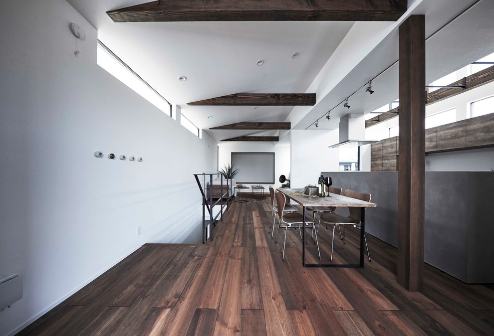 Foto de comedor urbano abierto con paredes blancas, suelo de madera oscura y suelo marrón
