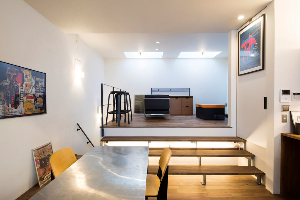 Exemple d'une salle à manger ouverte sur le salon moderne avec un mur blanc, un sol en bois brun et un sol marron.