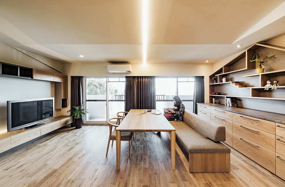 Esempio di una sala da pranzo design con pavimento in legno massello medio e pavimento marrone
