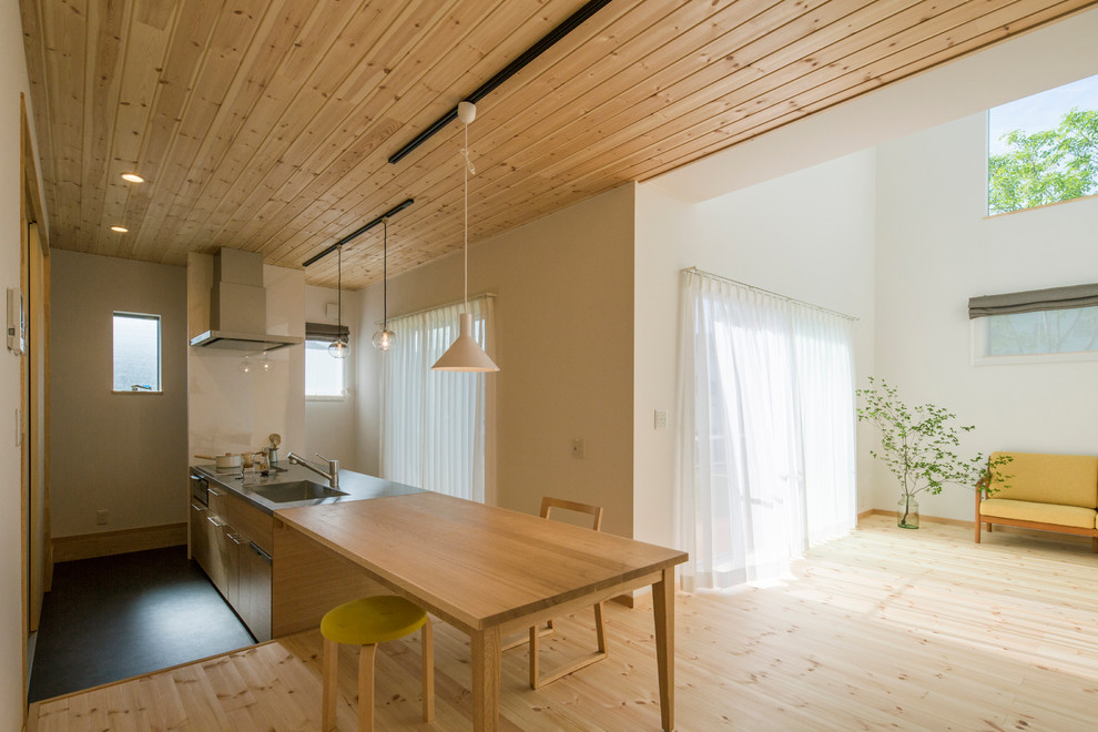 Exempel på en nordisk matplats med öppen planlösning, med vita väggar, ljust trägolv och brunt golv