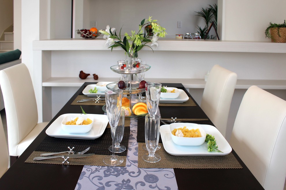 Foto di una sala da pranzo aperta verso il soggiorno design con parquet chiaro, pavimento beige e pareti bianche