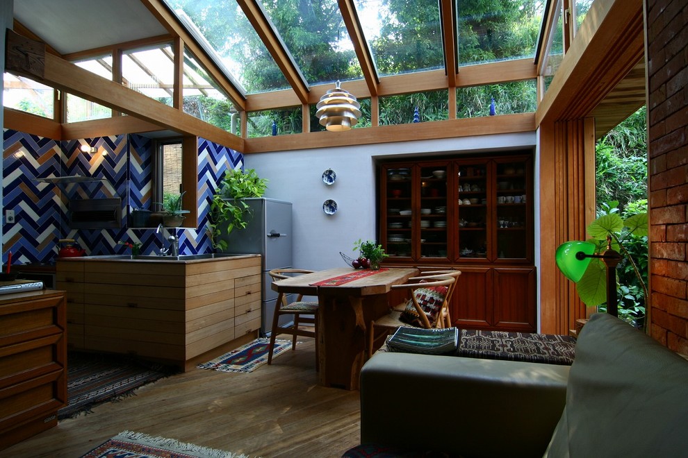 Réalisation d'une salle à manger ouverte sur le salon design avec un mur blanc, un sol en bois brun et un sol marron.