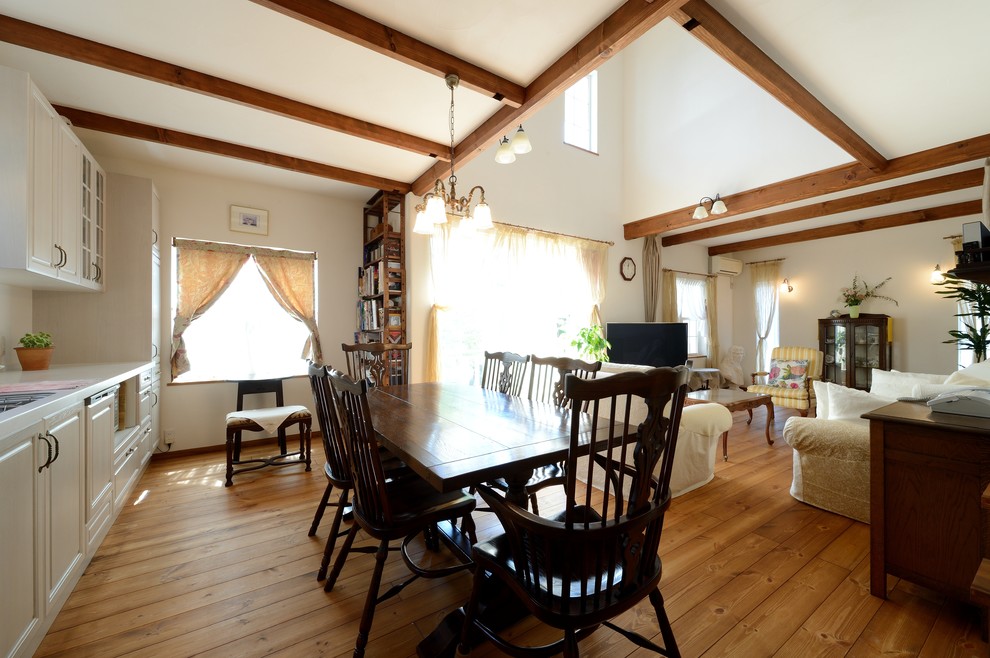 This is an example of a rustic open plan dining room in Nagoya with white walls, medium hardwood flooring and no fireplace.