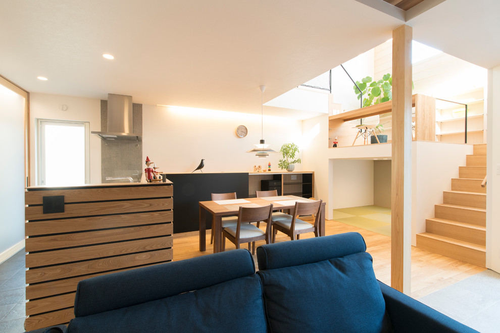 Esempio di una sala da pranzo aperta verso il soggiorno moderna di medie dimensioni con pareti bianche e pavimento marrone