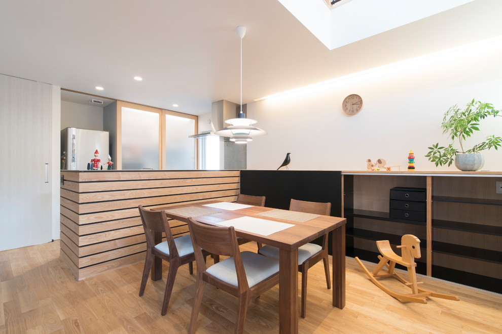 Aménagement d'une salle à manger moderne avec parquet clair et un sol beige.