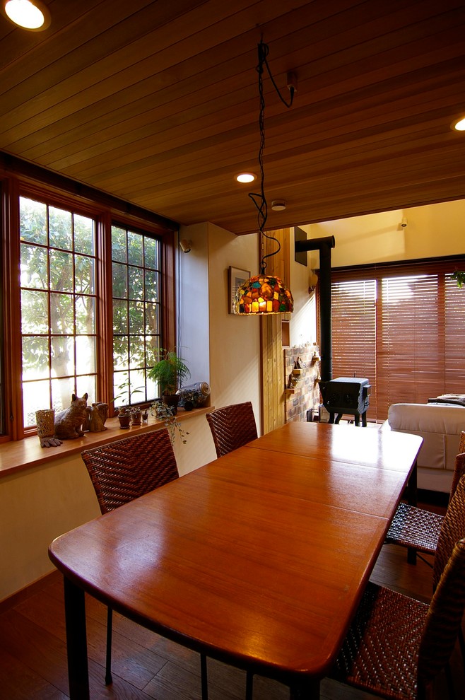 Immagine di una sala da pranzo country con pareti bianche, parquet scuro e pavimento marrone