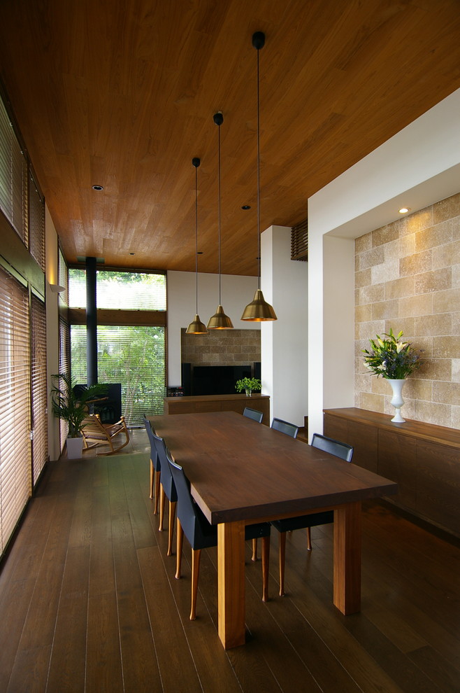 Diseño de comedor asiático con paredes blancas, suelo de madera oscura y suelo marrón