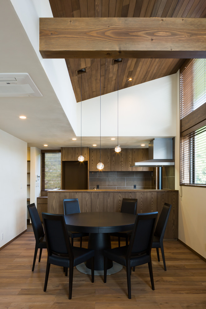 Inspiration pour une salle à manger vintage avec un mur blanc, un sol en bois brun et un sol marron.