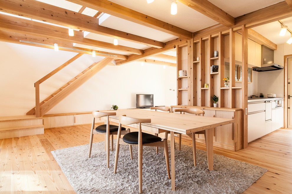 Ispirazione per una piccola sala da pranzo aperta verso il soggiorno etnica con pareti bianche e pavimento in legno massello medio