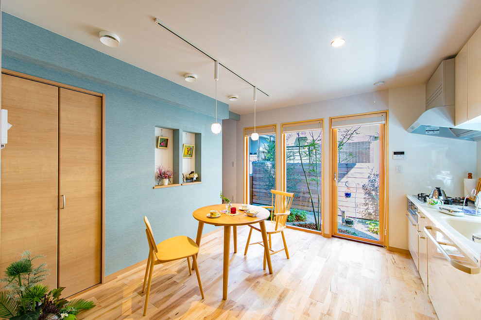 Immagine di una piccola sala da pranzo nordica con pareti blu, parquet chiaro e pavimento beige