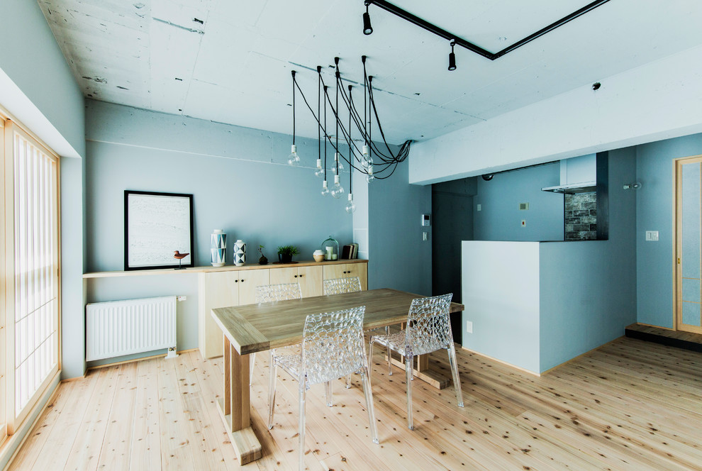 На фото: гостиная-столовая в стиле лофт с синими стенами, паркетным полом среднего тона и коричневым полом с