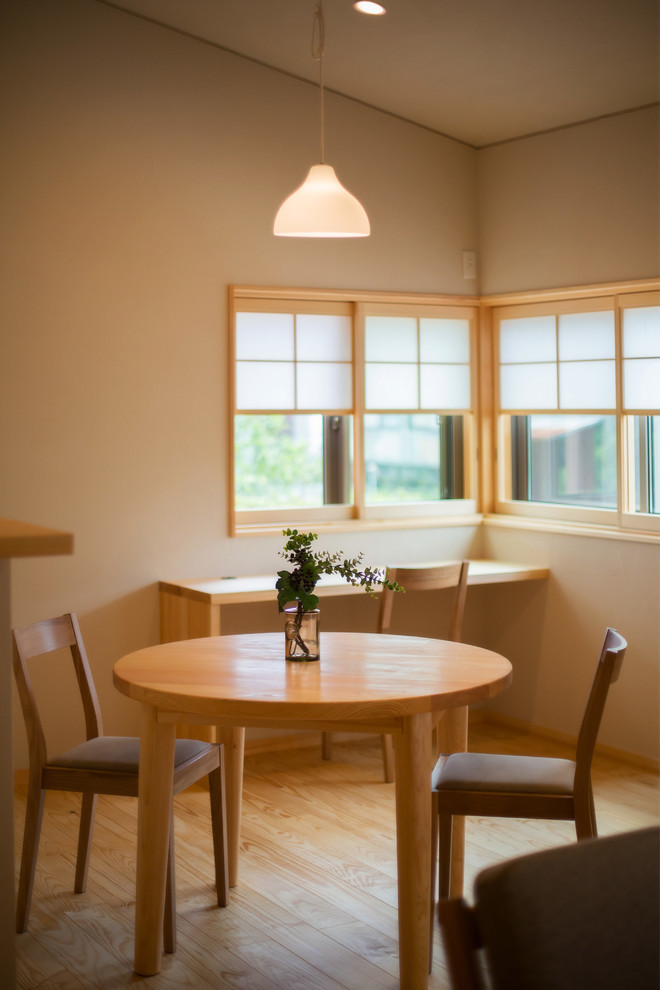 Foto di una piccola sala da pranzo minimal con pareti beige, parquet chiaro e pavimento beige