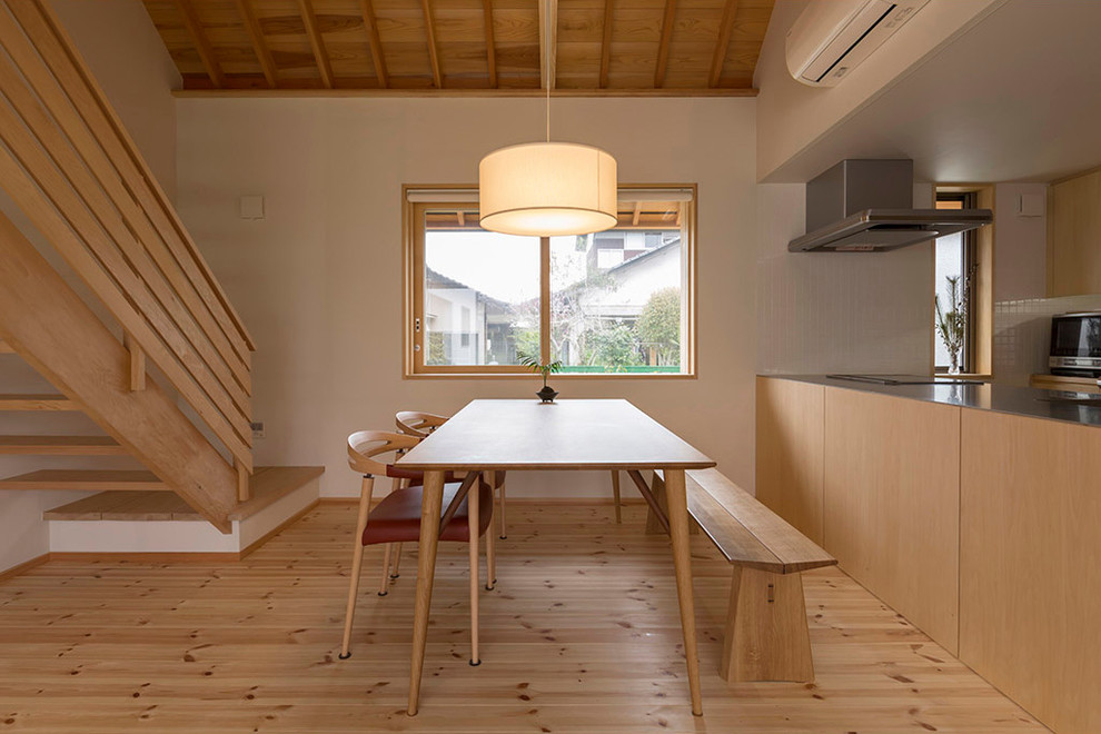 Idee per una sala da pranzo etnica con pareti bianche, pavimento in legno massello medio e pavimento marrone
