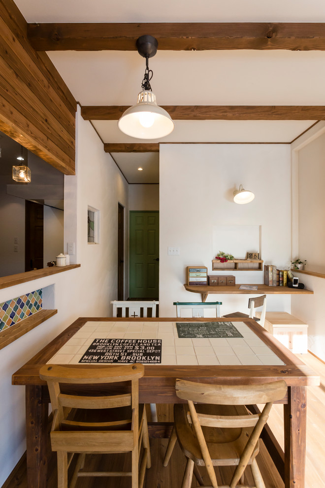 Immagine di una sala da pranzo mediterranea con pareti bianche, parquet chiaro e pavimento beige