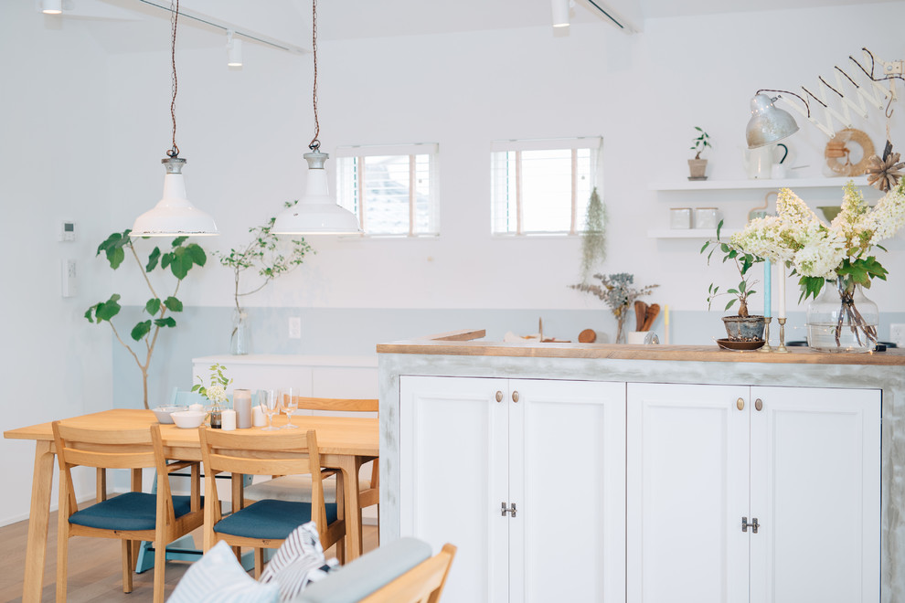 Idéer för att renovera en minimalistisk matplats med öppen planlösning, med vita väggar och mellanmörkt trägolv