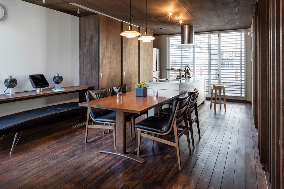 Esempio di una sala da pranzo aperta verso la cucina design con pareti bianche e parquet scuro