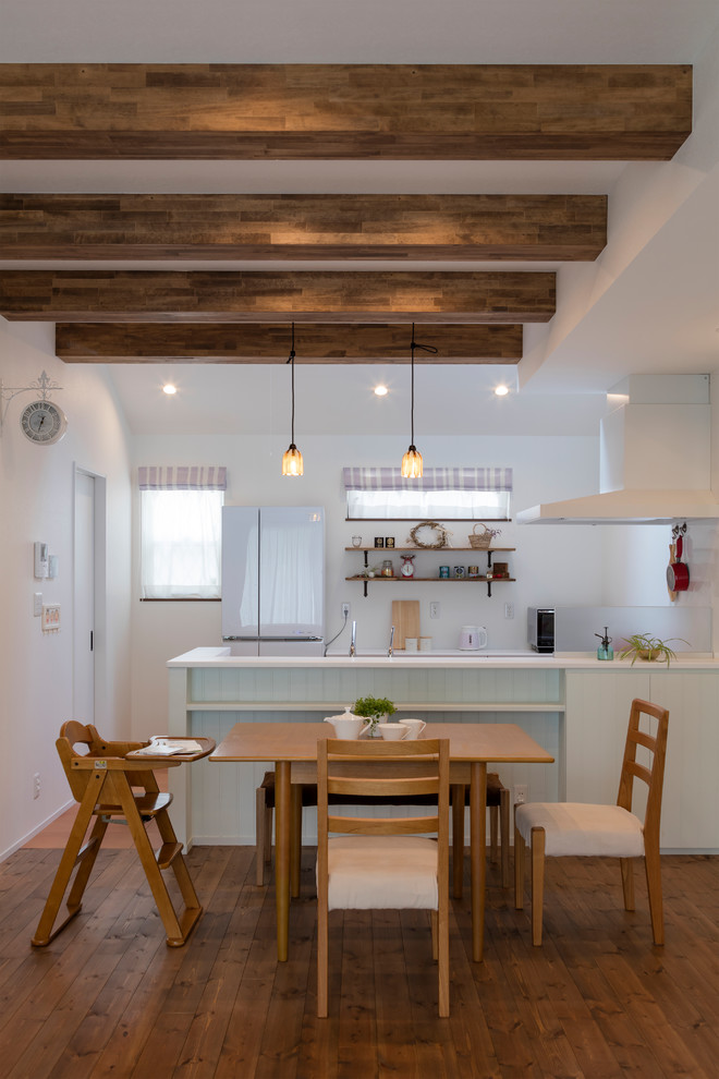 Ispirazione per una sala da pranzo aperta verso la cucina etnica con pareti bianche e pavimento in legno massello medio
