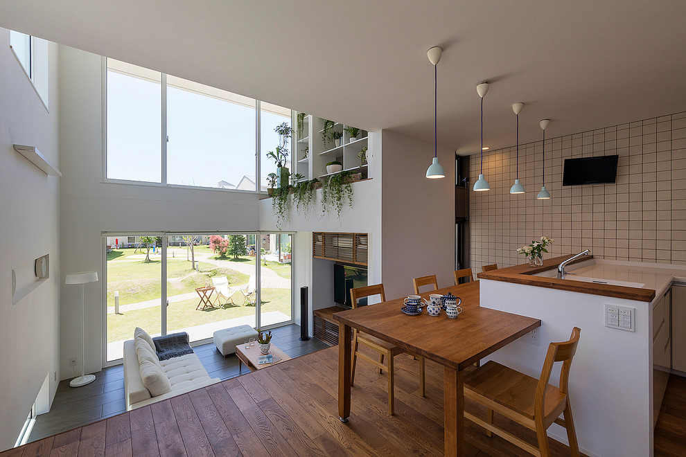 Immagine di una sala da pranzo minimal con pareti bianche, pavimento in legno massello medio e pavimento marrone