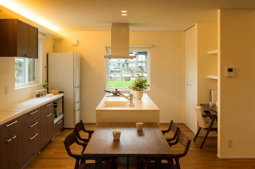 Esempio di una sala da pranzo aperta verso il soggiorno etnica con pareti beige, pavimento in legno massello medio e pavimento marrone