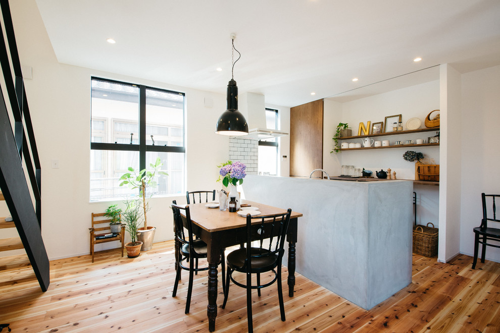 Idee per una sala da pranzo aperta verso il soggiorno moderna con pareti bianche, pavimento in legno massello medio e pavimento marrone