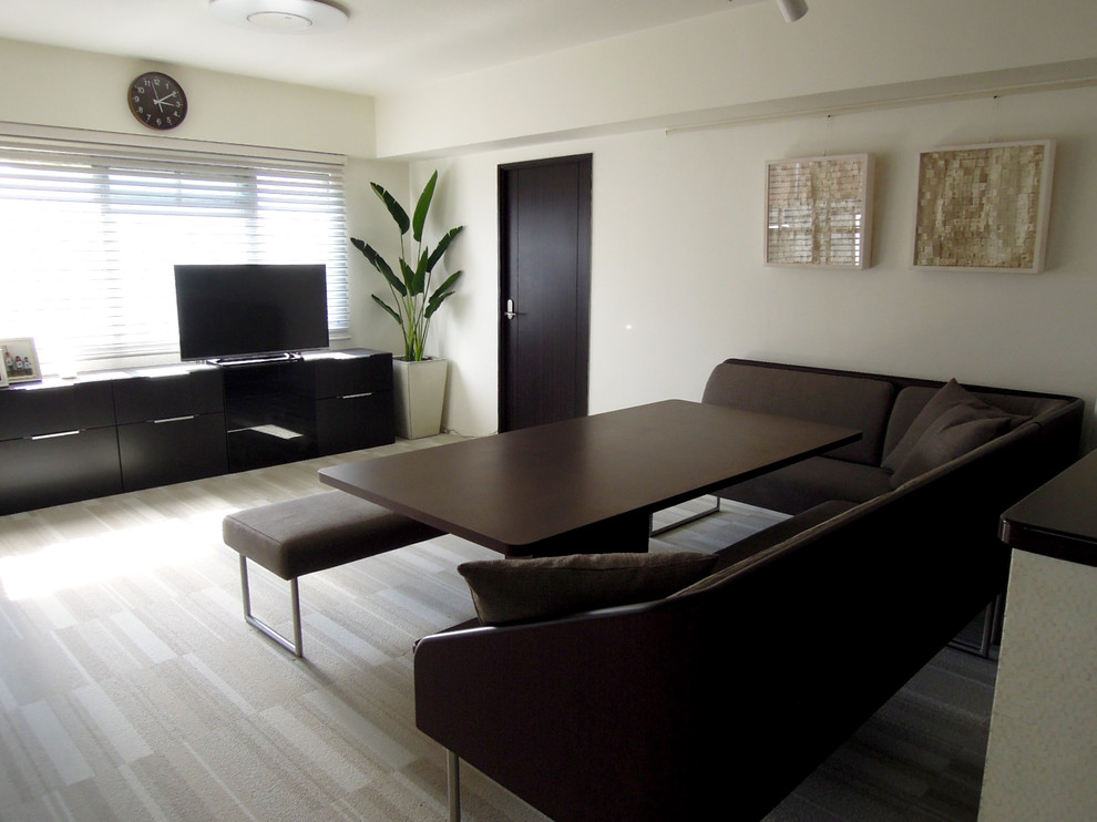 Immagine di una sala da pranzo aperta verso il soggiorno minimalista con pareti bianche, moquette e pavimento beige