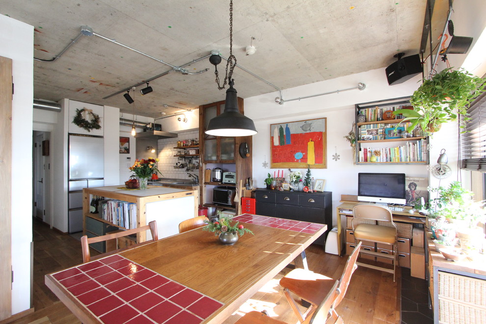 Esempio di una sala da pranzo industriale con pareti bianche e pavimento in legno massello medio