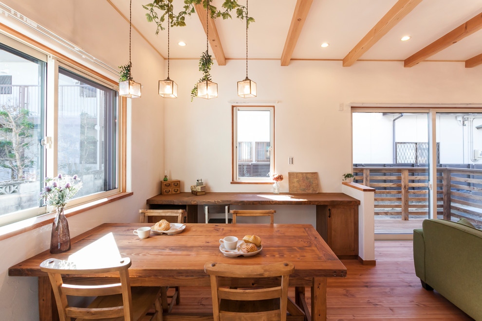 Exempel på en minimalistisk matplats med öppen planlösning, med vita väggar, mellanmörkt trägolv och brunt golv