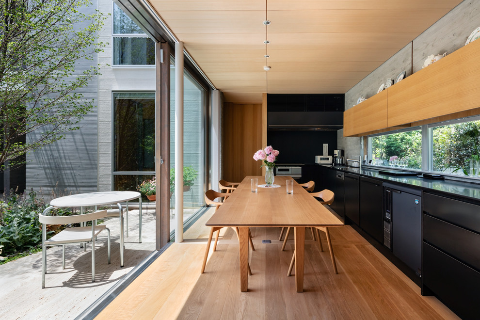 Стильный дизайн: кухня-столовая в стиле модернизм с серыми стенами, паркетным полом среднего тона и коричневым полом - последний тренд