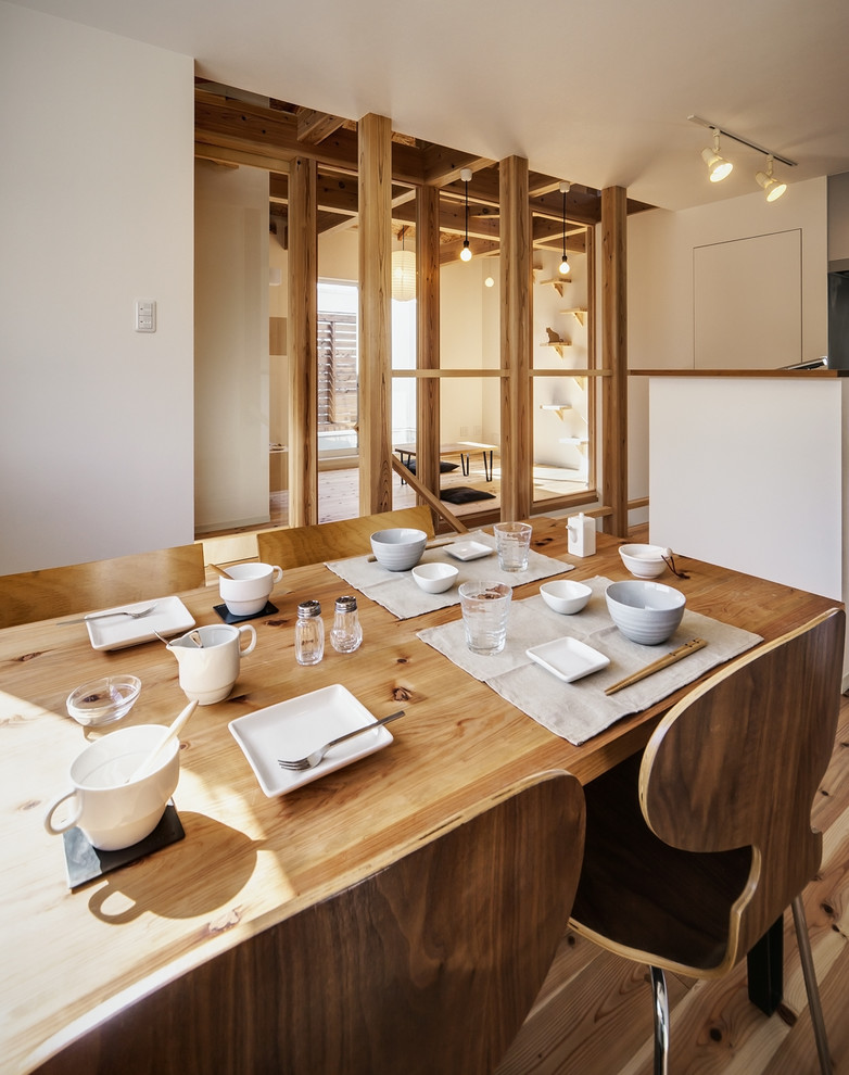 Esempio di una sala da pranzo aperta verso il soggiorno country con pareti bianche, pavimento in legno massello medio e pavimento marrone