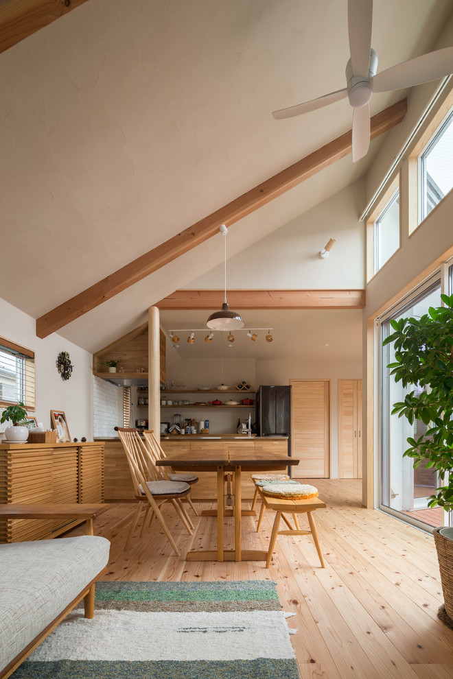 Foto de comedor de estilo zen de tamaño medio abierto sin chimenea con paredes blancas y suelo de madera clara