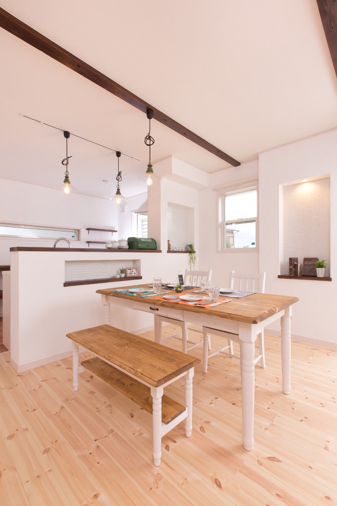 Imagen de comedor campestre abierto sin chimenea con paredes blancas, suelo de madera en tonos medios y suelo beige