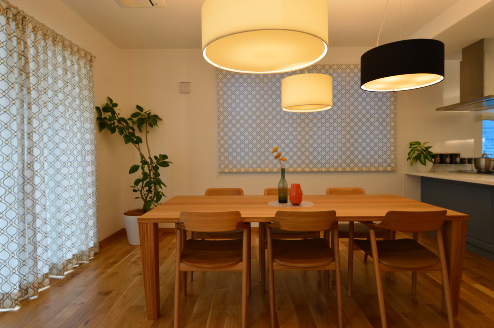 Пример оригинального дизайна: большая кухня-столовая в стиле модернизм с оранжевыми стенами и паркетным полом среднего тона без камина