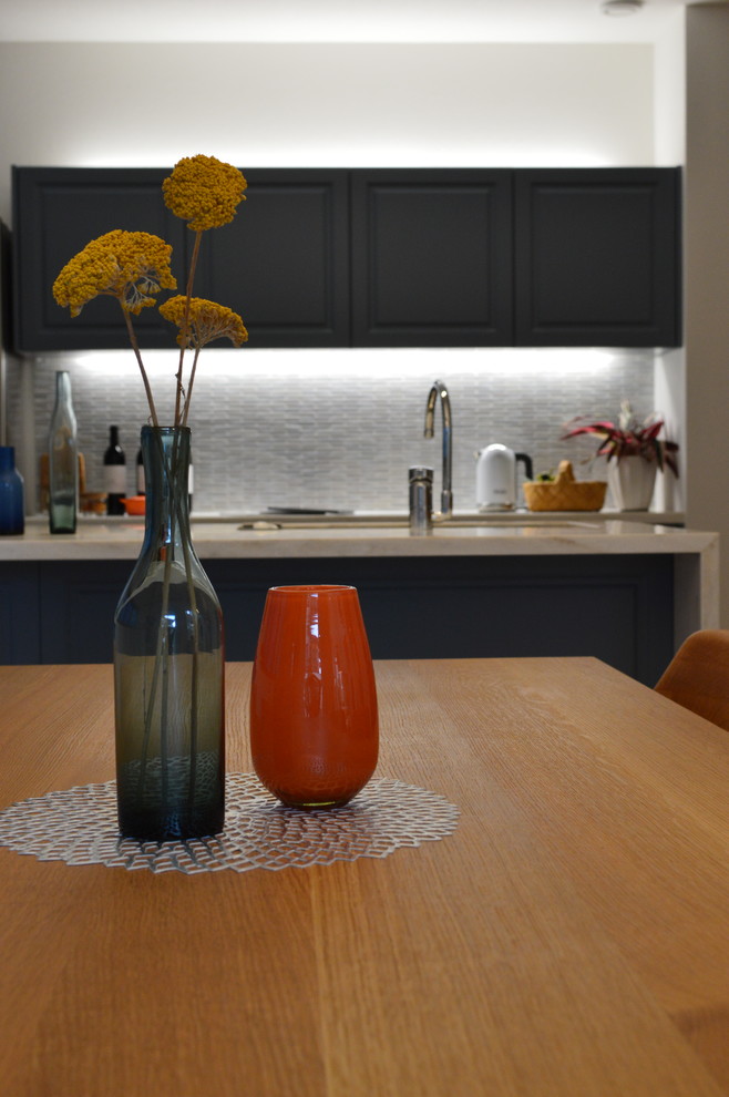 Imagen de comedor de cocina moderno grande sin chimenea con parades naranjas y suelo de madera en tonos medios