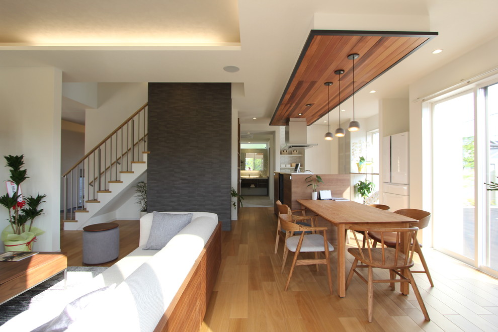 Esempio di una grande sala da pranzo aperta verso il soggiorno stile rurale con pareti grigie, pavimento beige e pavimento in legno massello medio