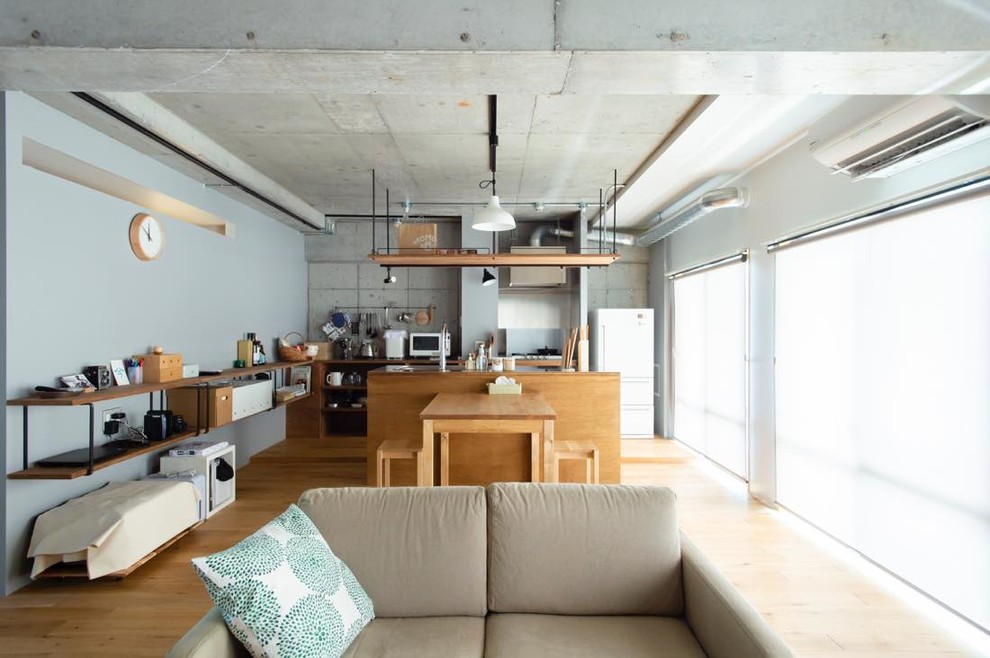 Ejemplo de comedor industrial abierto con paredes grises, suelo de madera en tonos medios y suelo marrón