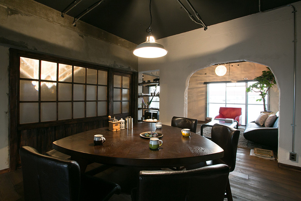 Inspiration pour une salle à manger urbaine avec un mur blanc, parquet foncé et un sol marron.