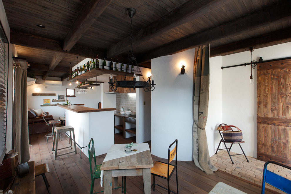 Imagen de comedor asiático abierto con paredes blancas y suelo de madera en tonos medios