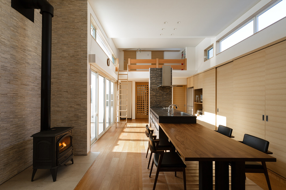 На фото: гостиная-столовая в стиле модернизм с разноцветными стенами, светлым паркетным полом и коричневым полом
