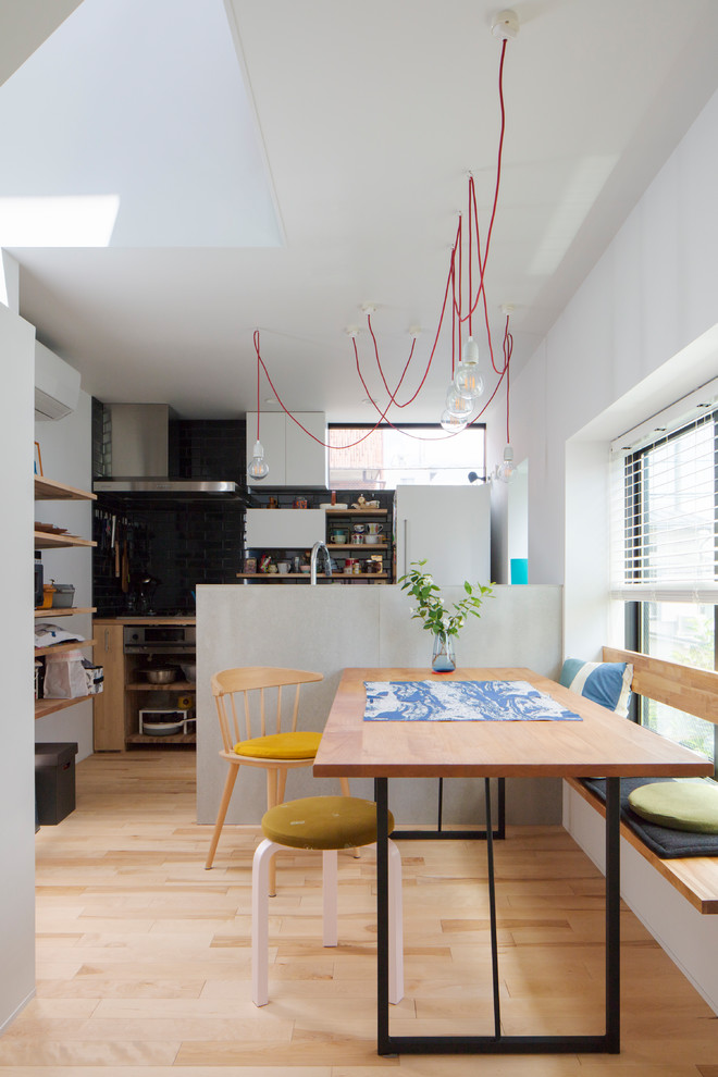 На фото: маленькая кухня-столовая с белыми стенами, светлым паркетным полом и бежевым полом без камина для на участке и в саду с
