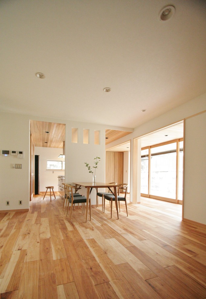 Rustikales Esszimmer ohne Kamin mit weißer Wandfarbe, braunem Holzboden und buntem Boden in Sonstige